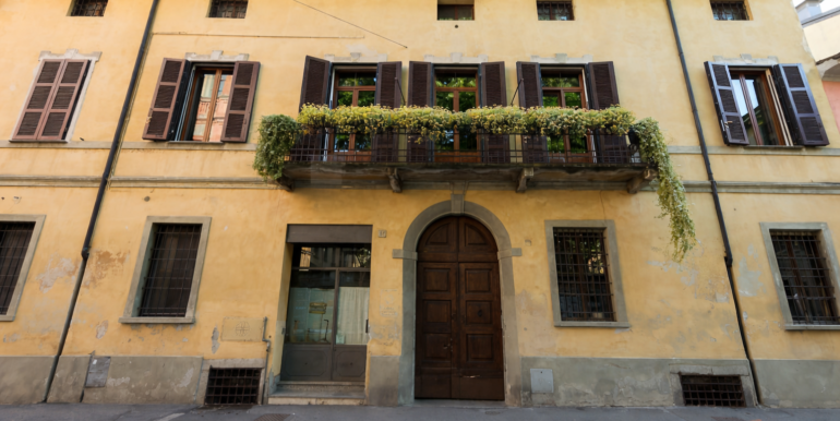 Edificio giallo con balcone fiorito